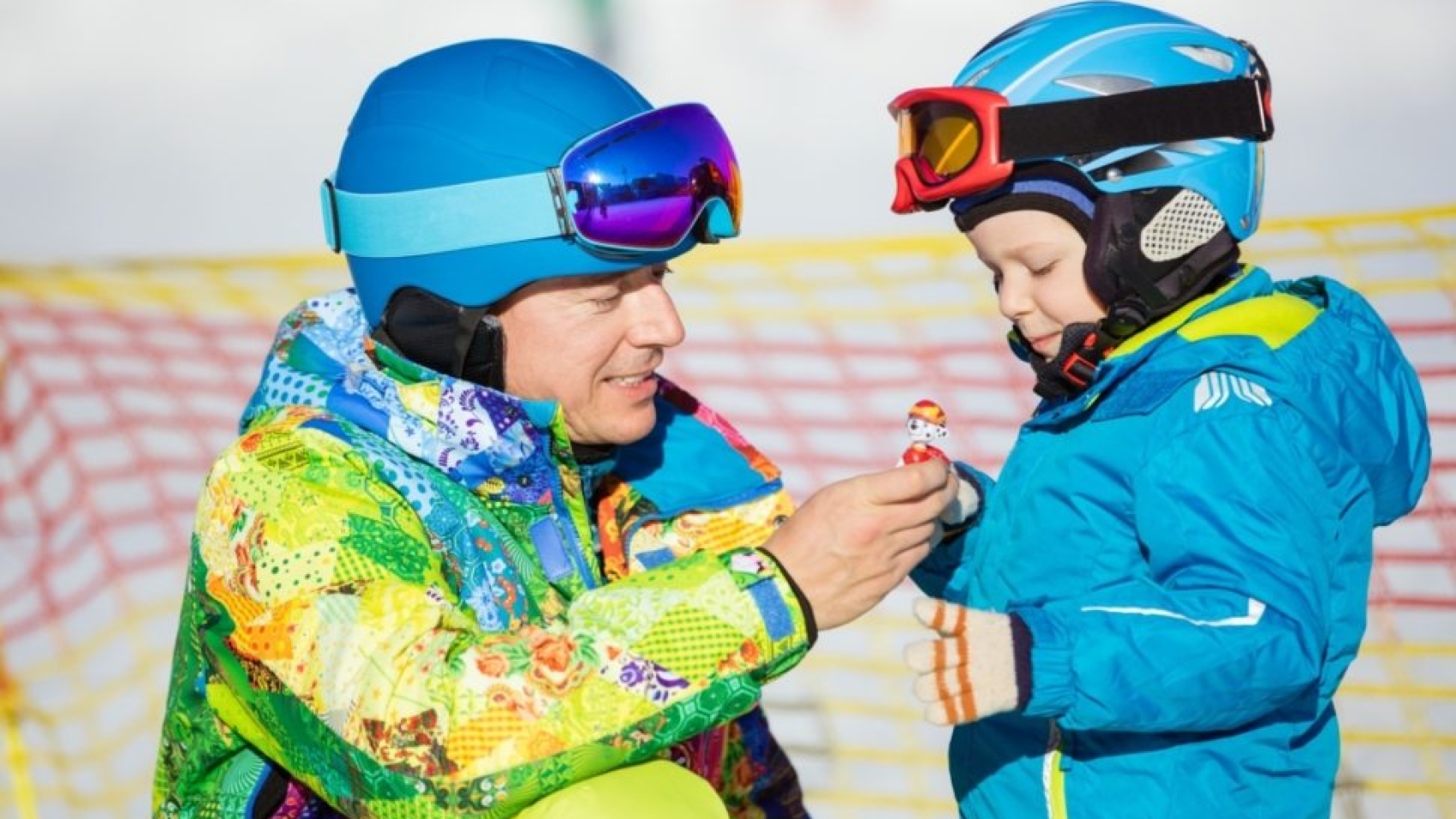 father-and-little-son-in-skiing-outfits-playing-PMSY642-970x660